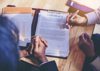 Businessman reading documents at meeting, business partner consi